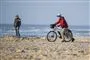 Cyklist på strand i strålende solskin