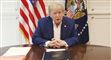 Donald Trump sidder ved et bord og taler