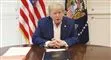 Donald Trump sidder ved et bord og taler