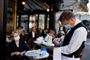 Tjener med mundbind på cafe i Paris