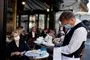 Tjener med mundbind på cafe i Paris
