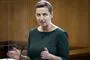 Statminister Mette Frederiksen i grøn kjole på folketingets talerstol 