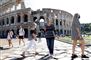 Turister med mundbind går foran Colosseum