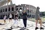 Turister med mundbind går foran Colosseum