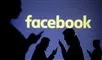 Silhoutter med mobiltelefoner og et Facebook skilt i baggrunden