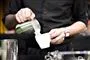 mand hælder mælk fra kande i kaffekop 