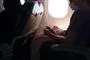 Billede inde fra et fly man ser en række personer i modlys fra flyets genkendelige runde vindue
