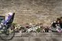 cykel med barn i barnesæde kører forbi blomster på fortovet