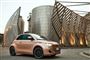 Fiat 500e ved en futuristisk bygning