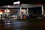 Tankstationen hvor skudene faldt. Billedet er taget i mørke. Der er to parkerede biler på tanken - en blå og en sølvfarvet.
