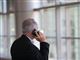 mand med ryggen til taler i telefon mens han kigger ud ad vindue