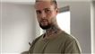 mand med tatoveringer kigger ind i kameraet 