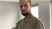 mand med tatoveringer kigger ind i kameraet 