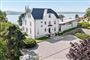 hvid villa med sø i baggrunden