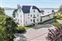 hvid villa med sø i baggrunden