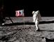 Astronaut på månen i rumdragt ved siden af det amerikanske flag.