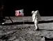 Astronaut på månen i rumdragt ved siden af det amerikanske flag.