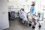 Læge tilser patient på hospitalsstue.