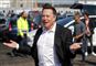 Elon Musk smiler og slår ud med armene