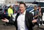 Elon Musk smiler og slår ud med armene