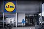 En Lidl-facade, hvor en mand kommer ud fra.