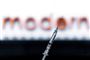en vaccinenål foran et logo merd Moderna