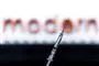 en vaccinenål foran et logo merd Moderna