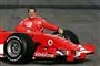 En smilende Michael Schumacher læner sig op af en Ferrari Formel 1-racer