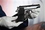 En lille pistol holdt af en mand med hvide handsker
