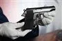 En lille pistol holdt af en mand med hvide handsker