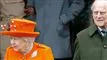 dronning elizabeth med orange hat sammen med sin mand prins hilip i grøn jakke