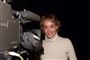 Anja Steensig i højhalset sweater står ved siden af tv-kamera