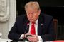 præsident Donald Trump sidder og taster på sin mobiltelefon