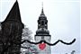En juledekoration foran et kirketårn