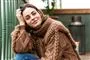 sarah grünewald i stor sweater med smil på læben 