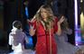 Mariah Carey i rød nedringet kjole synger på scenen
