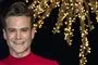 En smilende Silas Holst med noget guld tingel tangel ved siden af