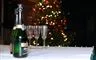 champagneflasker og glas på bord med fyrværkeri  baggrunden