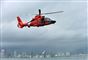 En orange helikopter svæver over vandet