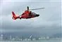 En orange helikopter svæver over vandet