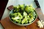 tallerken med broccoli står på et skærebræt