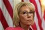  Betsy DeVos med amerikanske flag som baggrund