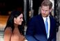 Meghan i brun stram bluse og harry kigger på hende
