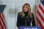 melania trump står mellem to amerikanske flag