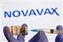 kanyle og glas med vaccine med firmanavet Novavax i baggrunden