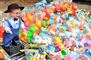 En plasticdukke af en lille dreng med pibe og en masse plastikdyr ved siden af