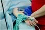 En arm med drops stikker ud fra en hospitalsseng