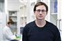 mand med briller står i laboratorie 