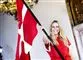 En meget glad Caroline Wozniacki i rød trøje med Dannebrog viftende foran sig. 