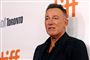 bruce springsteen står foran væg med reklamer